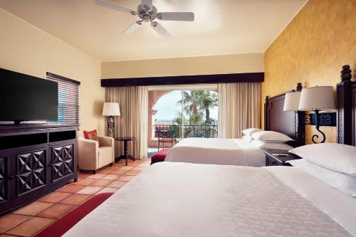 a hotel room with two beds and a flat screen tv at Hacienda del Mar Los Cabos, an Autograph Collection All-Inclusive Resort in Cabo San Lucas