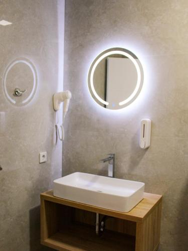 a bathroom with a white sink and a mirror at Sultan Apartments in Mostar