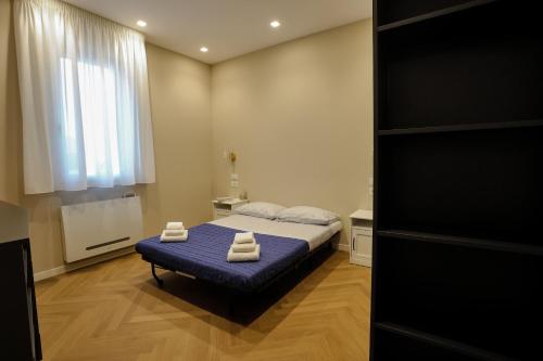 una camera da letto con un letto e due asciugamani di T&L-Home a Reggio di Calabria