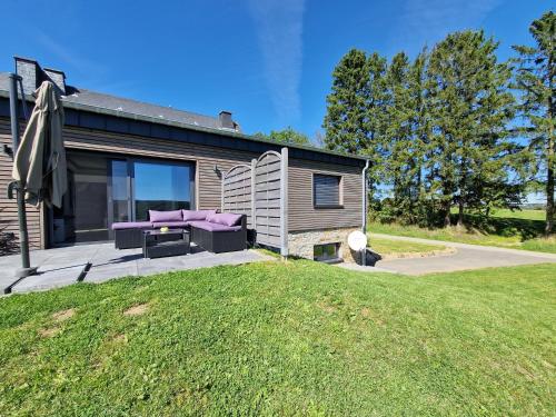 a house with a purple couch on a patio at Ferienwohnung Kessler's Eifeldomizil in Auw
