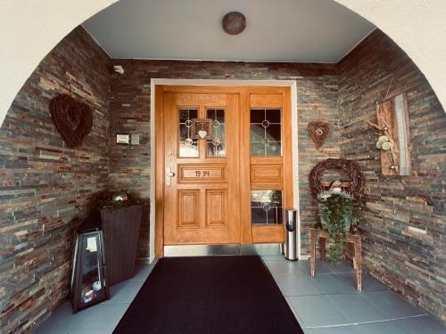 a hallway with a wooden door and a brick wall at Haus Lydia in See