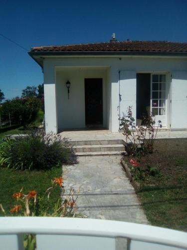 una piccola casa bianca con portico e porta di The bungalow a Saintes