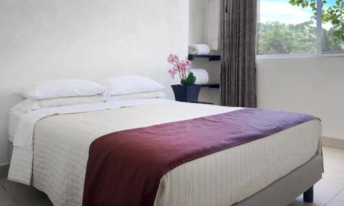 Un dormitorio con una cama grande y una ventana en HOTEL AMAZON GREEN, en Puerto Misahuallí