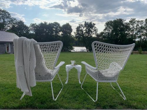 two white chairs and a table in a field at MAŁY PORT-Iława - Jezioro - Plaża - Marina priv - 5 pokoi VIP - czysto na 10 in Iława