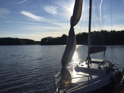 a boat is docked on the water on a lake at MAŁY PORT-Iława - Jezioro - Plaża - Marina priv - 5 pokoi VIP - czysto na 10 in Iława