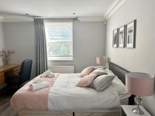 ein Schlafzimmer mit einem großen Bett mit rosa Kissen in der Unterkunft 2 Bed Sleeps 6 - Walking distance to Leeds City Centre!! in Leeds