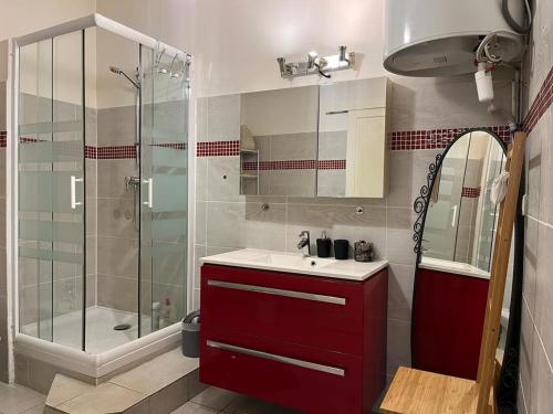 La salle de bains est pourvue d'un lavabo rouge et d'une douche. dans l'établissement Appartement Marseillais - Vieux Port, à Marseille