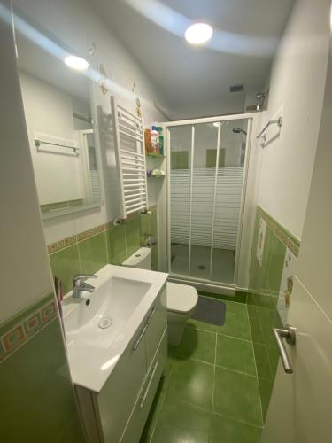 bagno con lavandino, servizi igienici e specchio di Chamartin De frente a 4 torres a Madrid