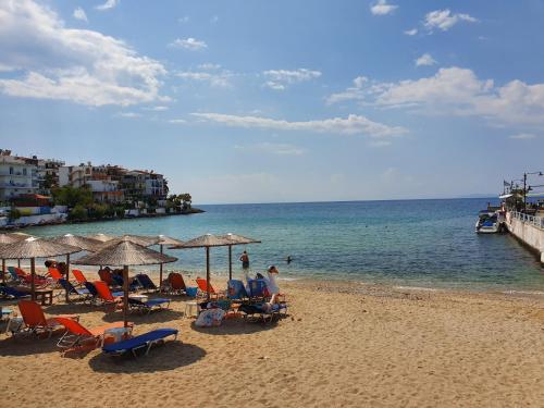 a beach with chairs and umbrellas and the ocean at Ilio Socrates in Skala Marion