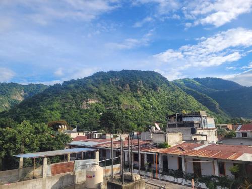 a view of a mountain with buildings and trees at Hostal Sweet Dreams in Panajachel