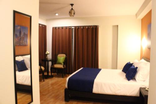 a hotel room with a bed and a desk with a chair at Hotel PLATINIUM in Tacna