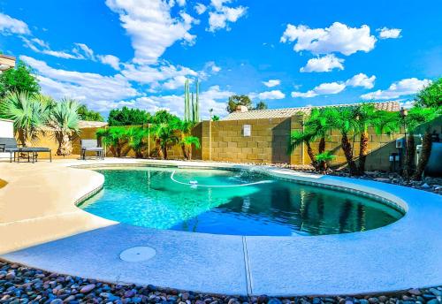 a swimming pool in a yard with palm trees at North Phoenix At Your Fingertips in Phoenix