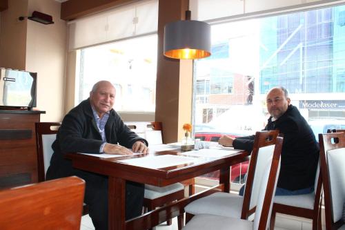 two men sitting at a table in a restaurant at Hotel PLATINIUM in Tacna