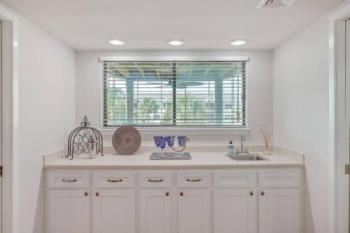a white kitchen with a sink and a window at New Listing! Port O' Call E203-Luxury Ocean View! in Isle of Palms