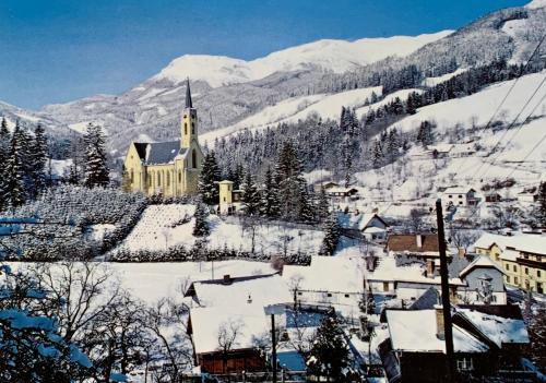 a church in the mountains with snow on the ground at Gemütliche Ferienwohnung - Prein an der Rax 