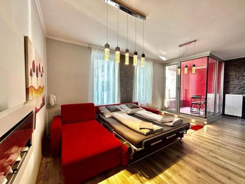 een slaapkamer met een rood bed en een rode bank bij Apartmánik v tichom nádvorí - free parking in Bratislava