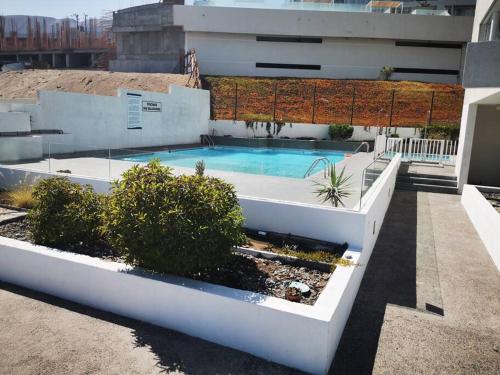 una piscina al lado de un edificio en frente a playa vista panorámica Departamento 3 Habitaciones 2 Baños Iquique en Iquique