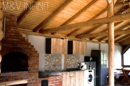 una cucina con forno in mattoni e muro di mattoni di M&V Infinit a Sălătrucel