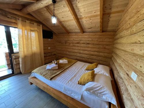 ein Schlafzimmer mit einem Bett in einem Holzzimmer in der Unterkunft M&V Infinit in Sălătrucel