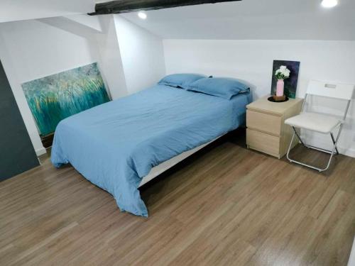a bedroom with a blue bed and a chair at home, sweet home in Vitry-sur-Seine