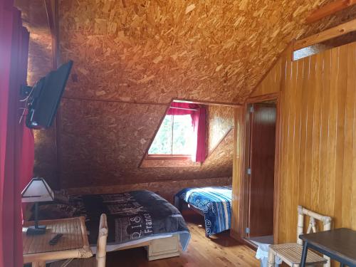 a small room with a bed and a window at Treff Lodge Hotel in Oxapampa