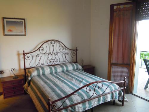 a bedroom with a bed with a striped blanket on it at Holiday Home Bel Panorama Due in Pelago