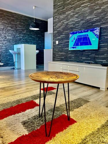 a table in a room with a tv on a brick wall at Apartmánik v tichom nádvorí - free parking in Bratislava