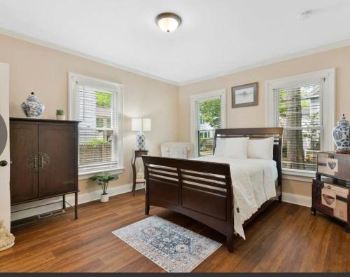 a bedroom with a bed and two windows at Beautiful Studio Apartment in Historic House in New Haven