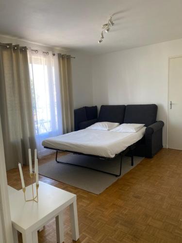 uma sala de estar com uma cama e um sofá em Petit cocon avec Balcon au centre de Marseille em Marselha