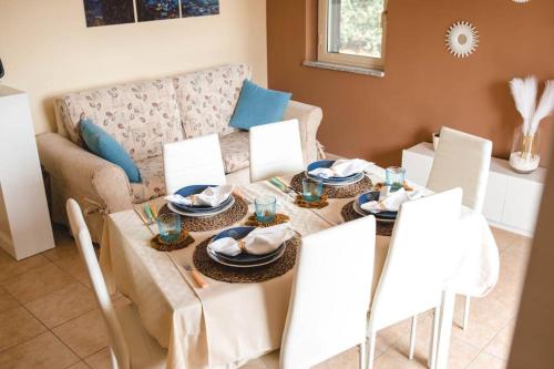 a dining room with a table and a couch at Artemide Apartment in Montepaone Lido