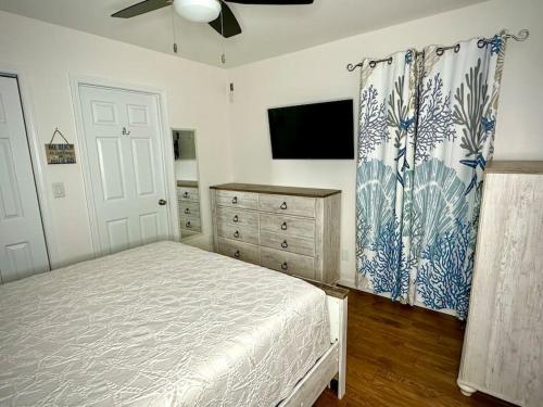 a bedroom with a bed and a flat screen tv at Backroad Blue in St. George Island