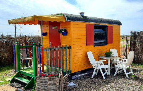 een klein speelhuisje met een tafel en stoelen bij B&B boerderij rust, in pipowagens! in Den Helder