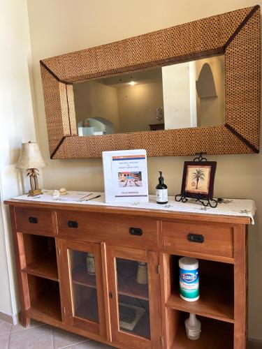 a wooden dresser with a large mirror on a wall at Perfect Sunset View in Palm-Eagle Beach