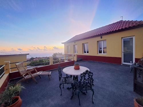 a patio with a table and chairs on a balcony at Calheta Countryside in Calheta