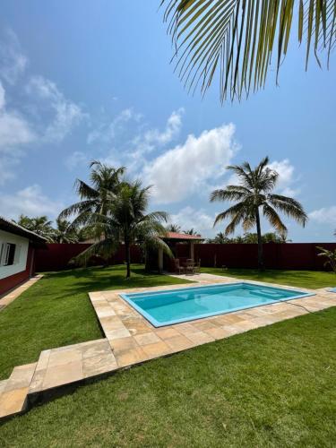 a swimming pool in a yard with palm trees at Kitesurf Oasis Maracajaú in Maracajaú