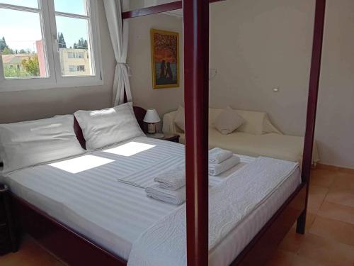 a bedroom with a bed with white sheets and a mirror at Private Villa AKOBARA, 2km from city center in Corfu Town