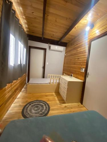 um pequeno quarto com uma cama e pisos em madeira em Chalé com VISTA para o vale e Churrasqueira- a 6km do Centro em Ibicaré