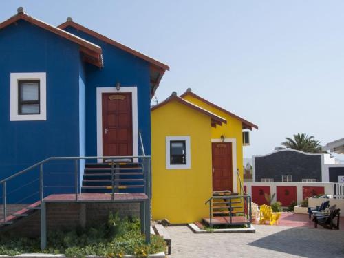 a colorful house with two doors in a parking lot at Wildhorses B&B and Self Catering in Lüderitz
