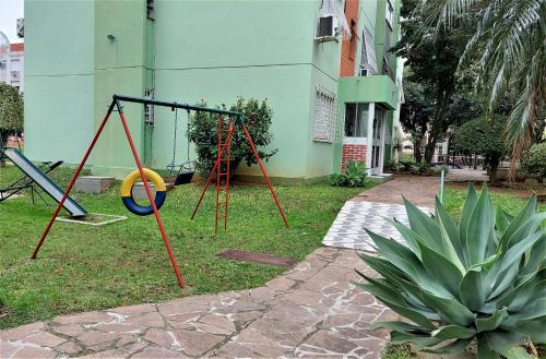 a playground in a yard next to a building at Apartamento Top, 3 quartos, Wi-Fi 300 Mbps in Porto Alegre