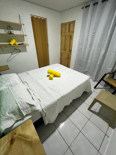 Un dormitorio con una cama con un objeto amarillo. en Cabinas Golfito, en Golfito