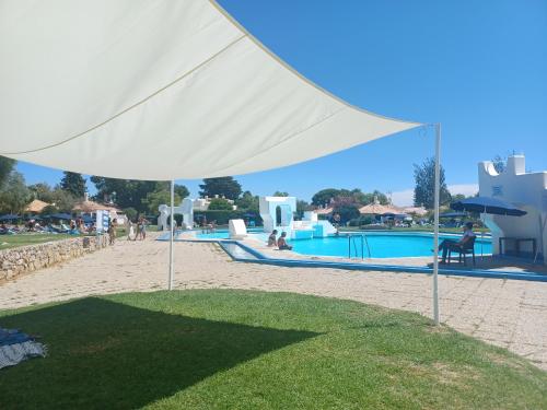 a white tent in front of a swimming pool at Pedras D` EL Rei Village 110 in Tavira