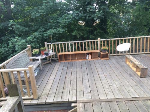 a wooden deck with benches and a dog sitting on it at Large Room in share house in Meanwood