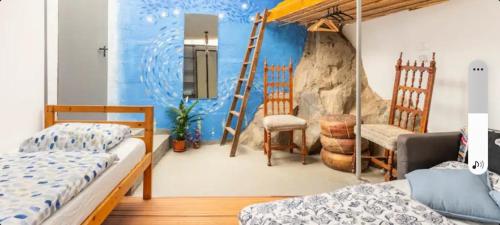 1 dormitorio con 2 camas y pared de piedra en Twin room in the greenhouse close to mountains and surf paradise, en Tejina