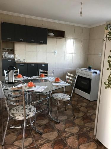 a kitchen with a table and chairs and a stove at Casa aconchegante em Catas Altas in Catas Altas