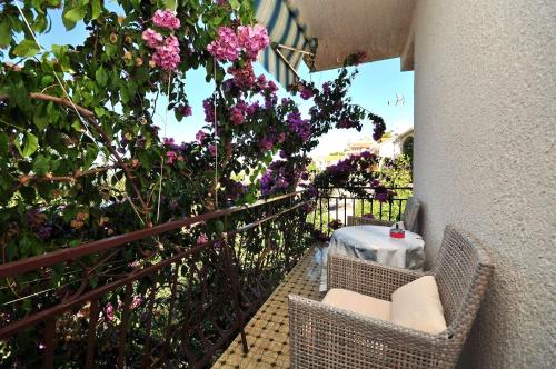 a balcony with a table and chairs and flowers at Apartments Ruzarija in Trogir