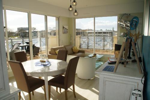 un salon avec une table, des chaises et un canapé dans l'établissement Thermes & Vacances Residence ATLANTICA, à Rochefort