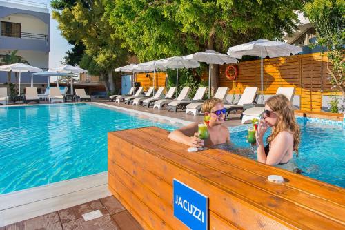 two people in a swimming pool with drinks at Sunny Days Hotel in Ixia