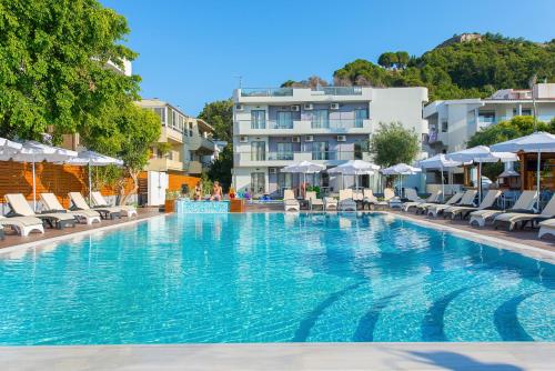 a large swimming pool with chairs and umbrellas at Sunny Days Hotel in Ixia