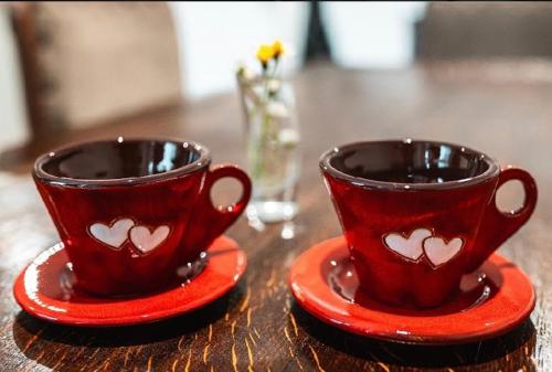 dos tazas rojas con corazones en una mesa en Holiday House with Sauna, en Východná