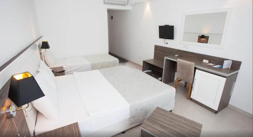 a room with two beds and a desk and a mirror at Club Shark Hotel in Gümbet